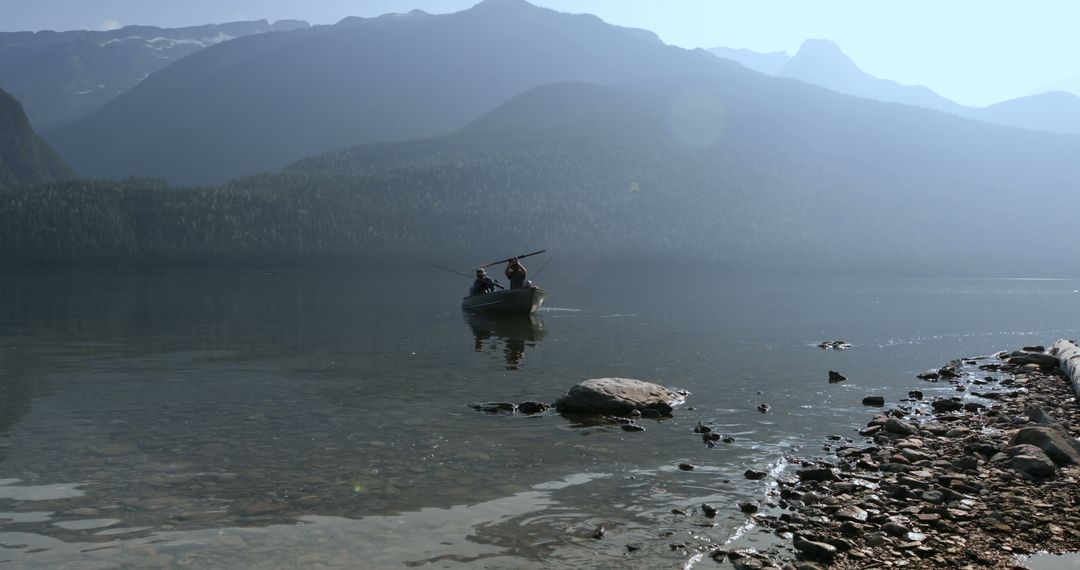 A person relishes tranquil fishing amidst a mountainous lakescape with  serene, still waters. from Pikwizard