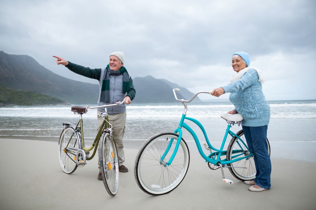 Senior couple standing with bicycles on the beach  - Free Images, Stock Photos and Pictures on Pikwizard.com
