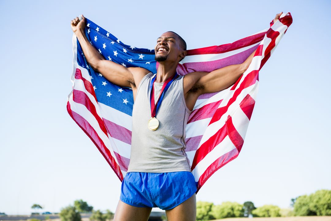 Athlete posing with american flag and gold medals around his neck - Free Images, Stock Photos and Pictures on Pikwizard.com
