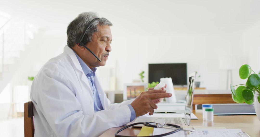 Senior biracial male doctor using headset and laptop for image consultation call - Free Images, Stock Photos and Pictures on Pikwizard.com