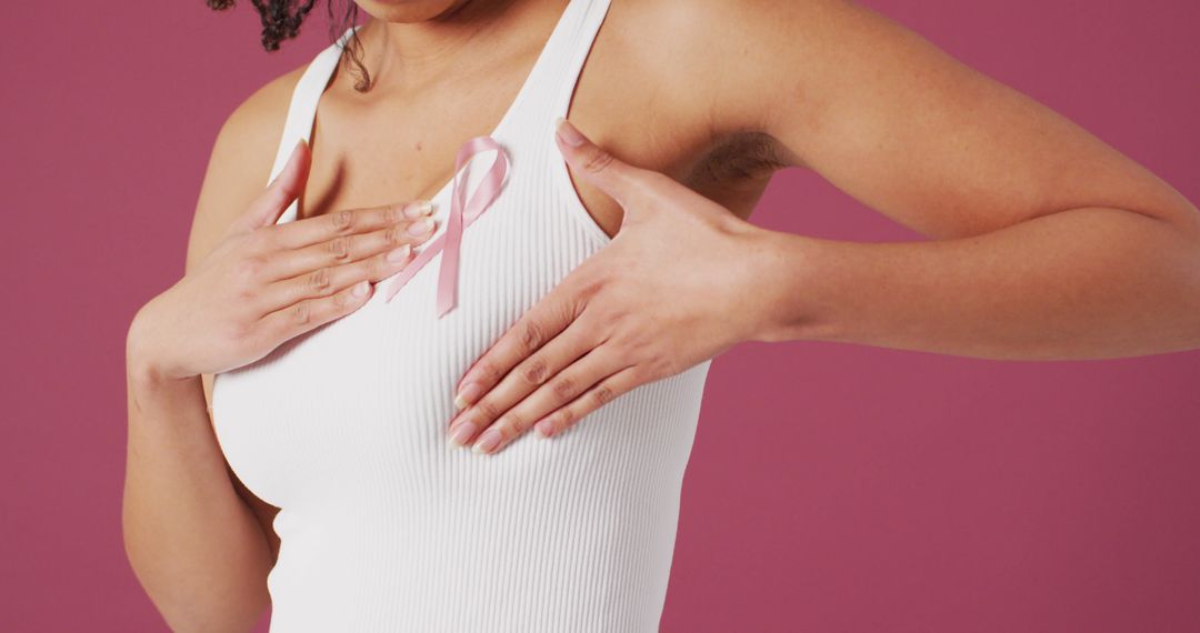 Breast Cancer Awareness Ribbon. White and red bra with pink ribbon tape  lying on female bra