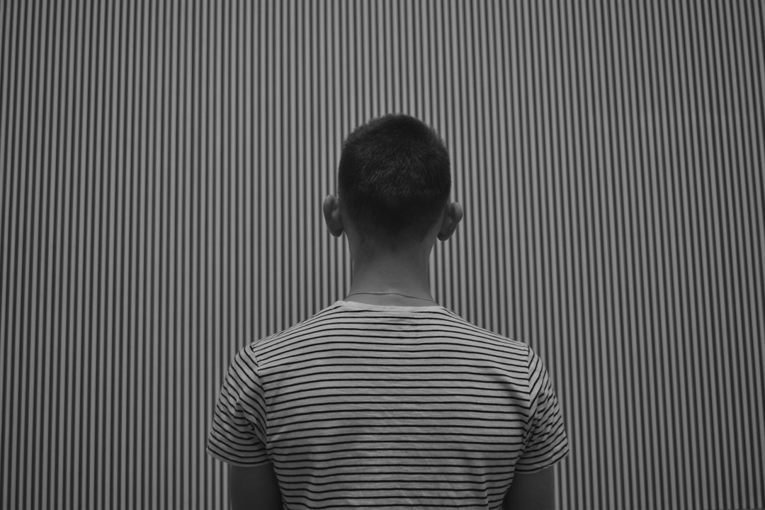 a man standing in front of a striped wall - Free Images, Stock Photos and Pictures on Pikwizard.com