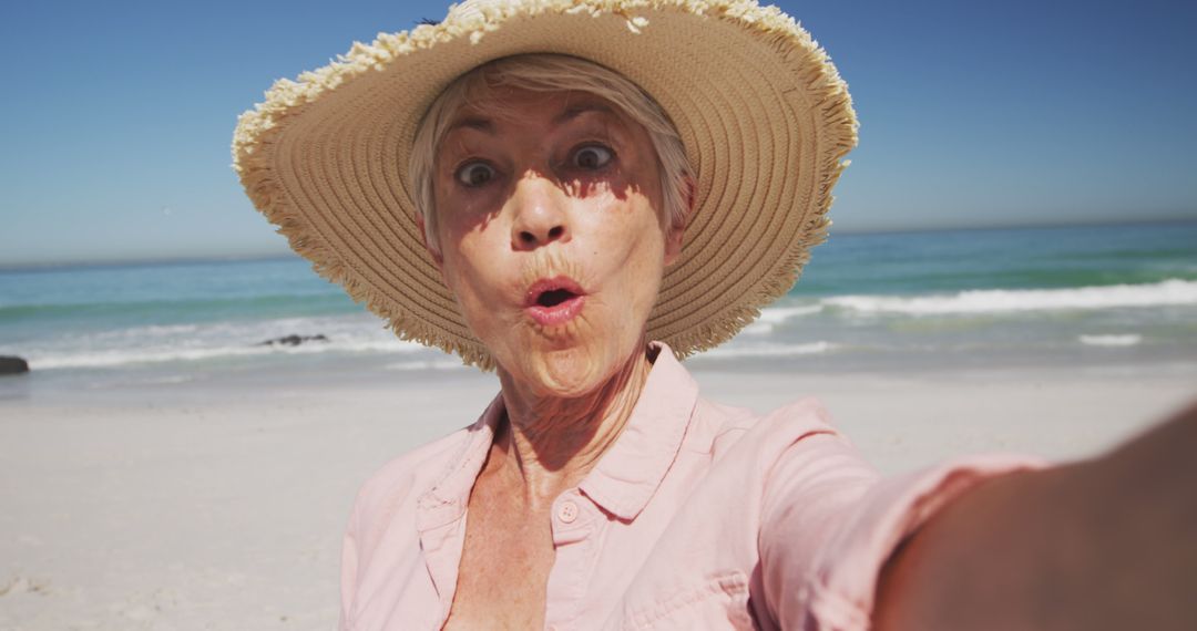 Happy senior caucasian woman taking selfie on beach - Free Images, Stock Photos and Pictures on Pikwizard.com