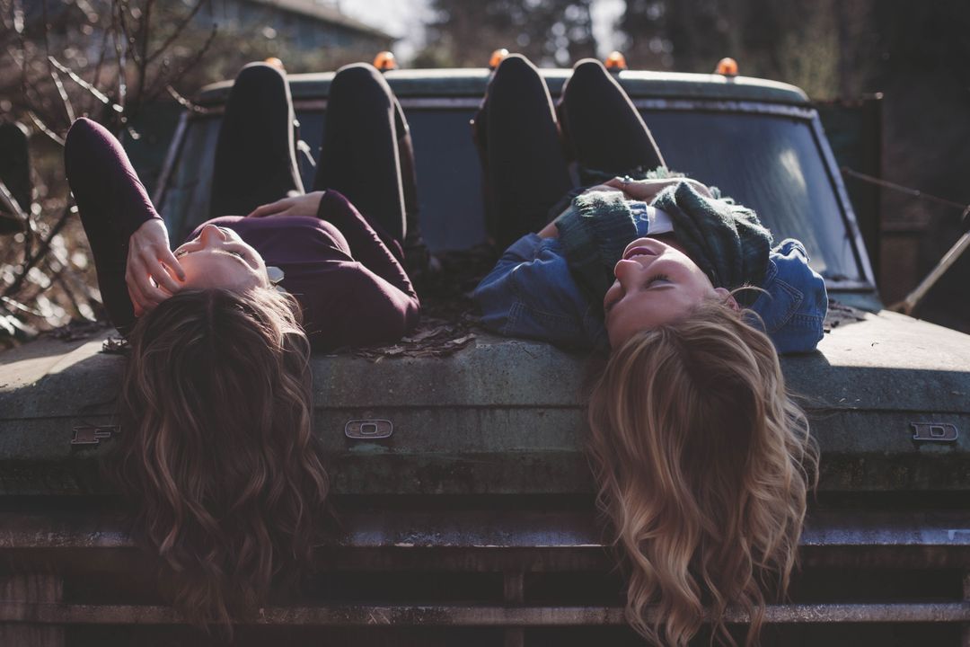 two girls laying on the back of a truck - Free Images, Stock Photos and Pictures on Pikwizard.com