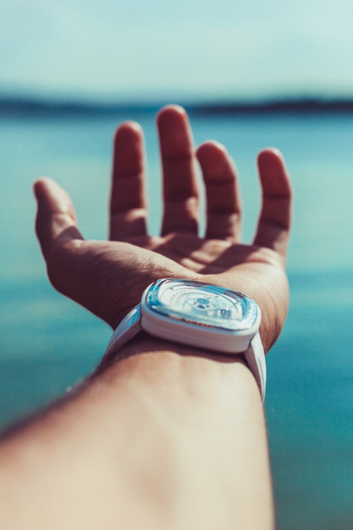 a person holding a wrist watch - Free Images, Stock Photos and Pictures on Pikwizard.com