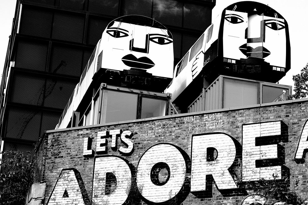 Black and White Image of a Graffiti saying 'Let's Adore' on a Wall