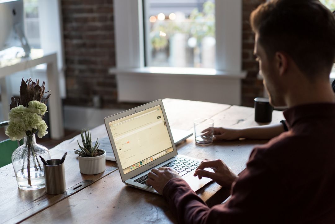 Over the shoulder image of a blogger typing on their laptop - Simple but powerful tactics for crafting compelling ad copies that drive sales - Image