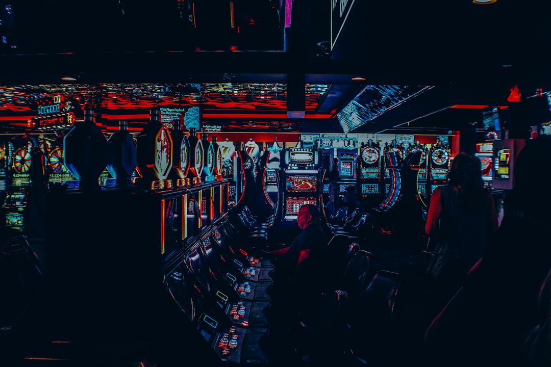 Photograph of dark casino with neon lights