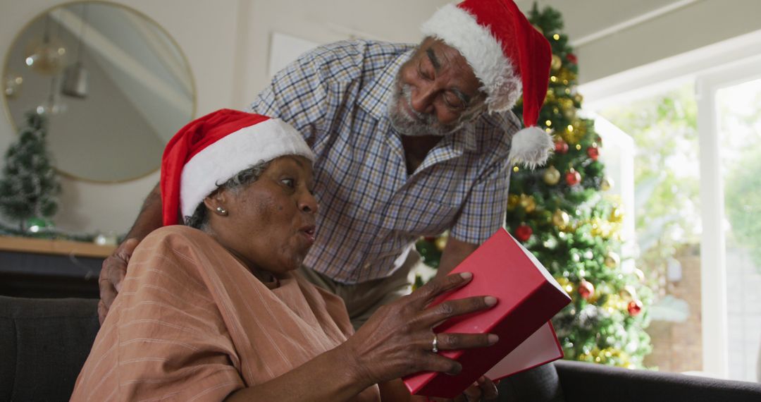 Image of happy african american senior couple sharing with presents at christmas time - Free Images, Stock Photos and Pictures on Pikwizard.com