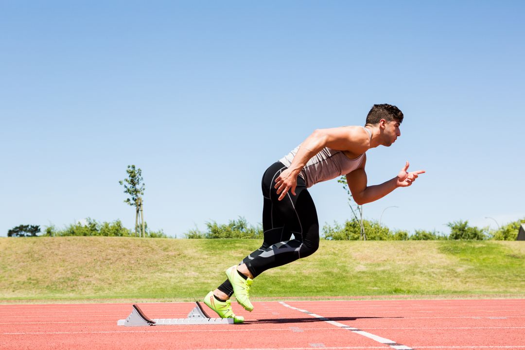 Man running on a track field on a sunny day