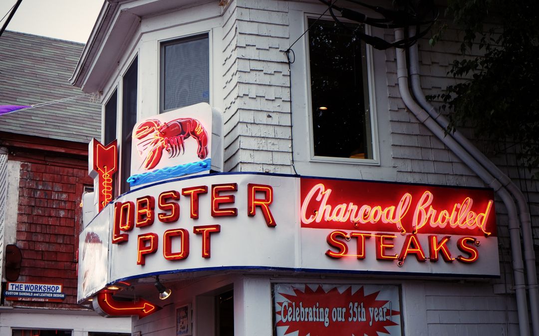 Image of a restaurant called Lobster Pot with red neon signs 