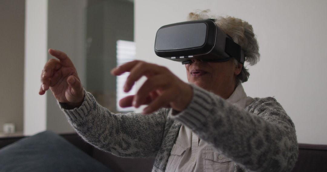 African american senior woman gesturing while wearing vr headset at home - Free Images, Stock Photos and Pictures on Pikwizard.com