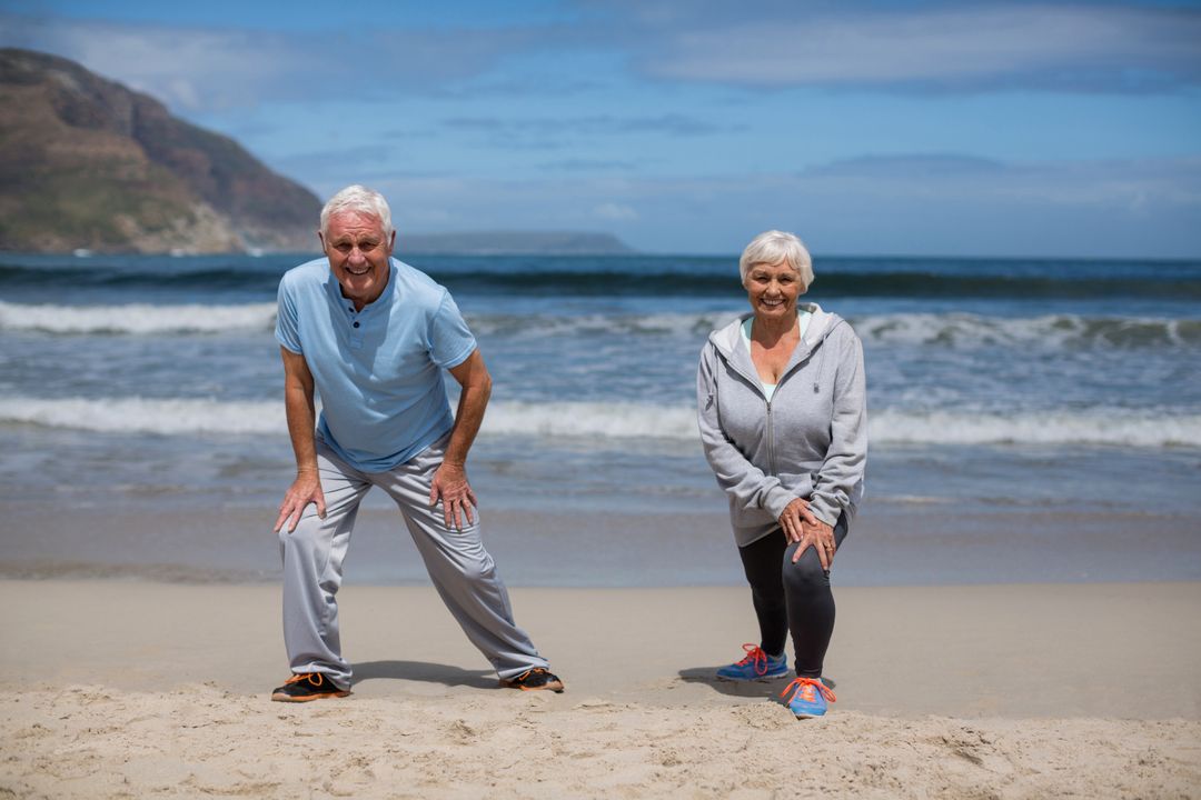 Senior couple doing stretching exercise on the beach - Free Images, Stock Photos and Pictures on Pikwizard.com