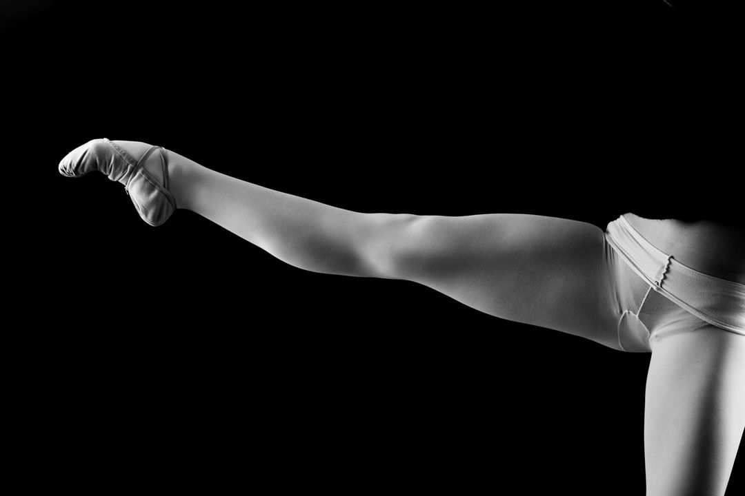 Black and white image of ballerina lifting her leg