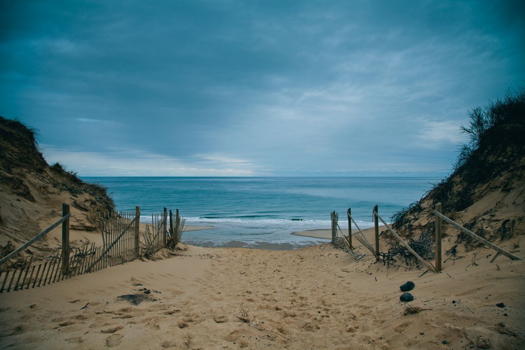 a beach with a fence and sand - Free Images, Stock Photos and Pictures on Pikwizard.com