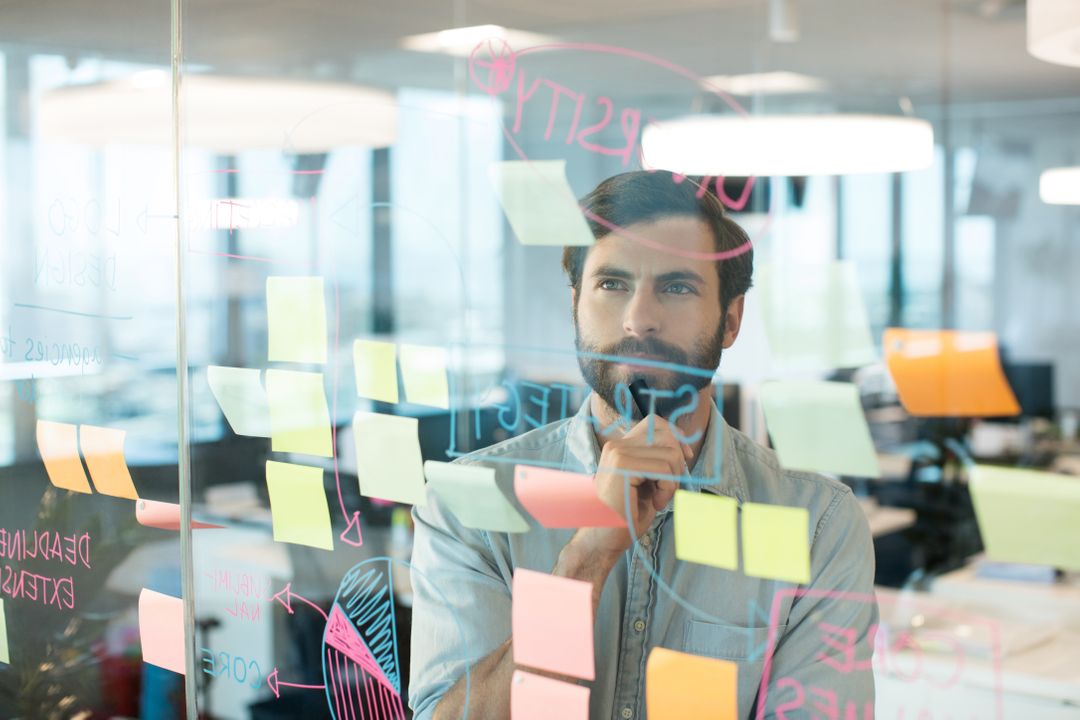 Image of a Man Standing in Front of a Glass Wall with Sticky Notes