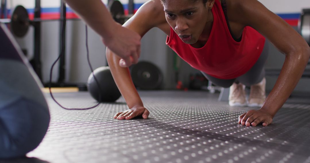Image of diverse fitness trainer and woman doing push ups high fiving at a  gym from Pikwizard