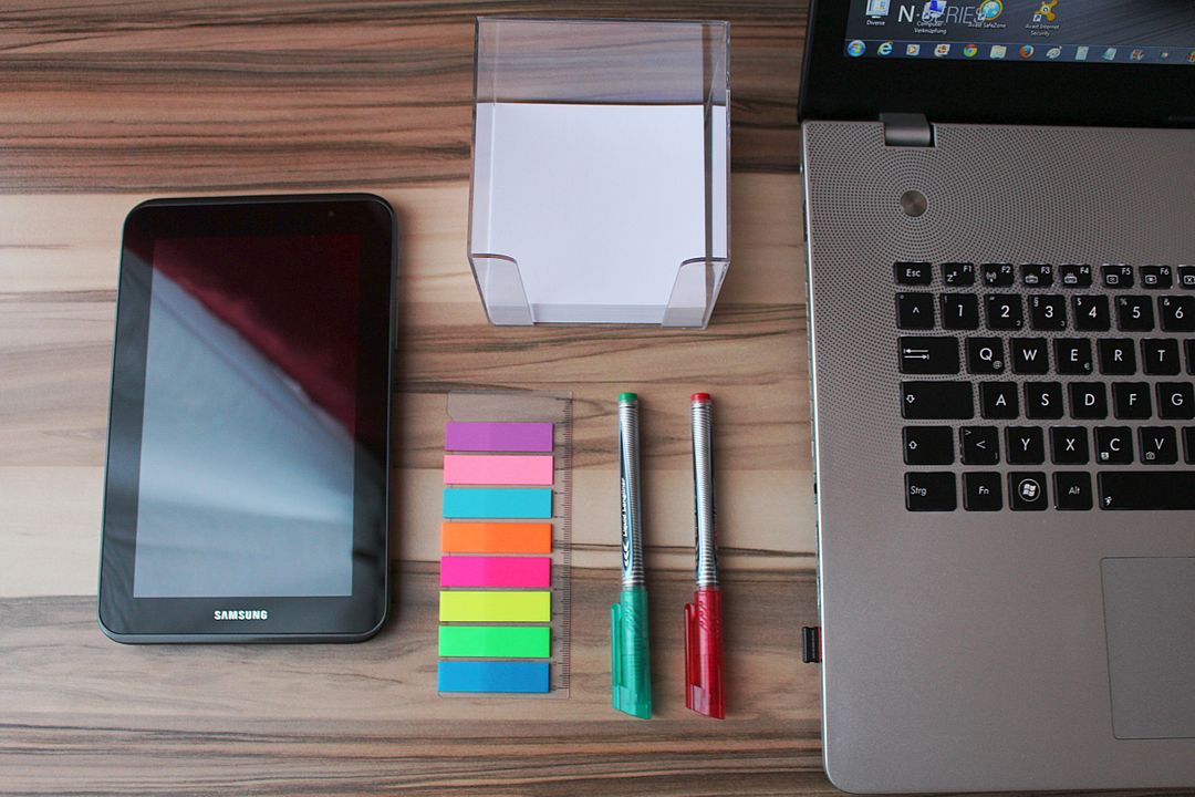 Image of a Desk with a Laptop, a Tablet and Sticky Notes