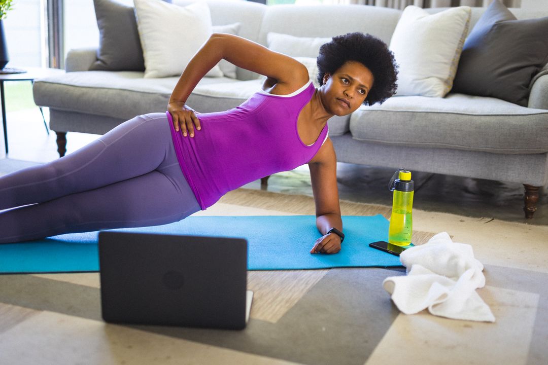 African american mid adult woman practicing yoga during online