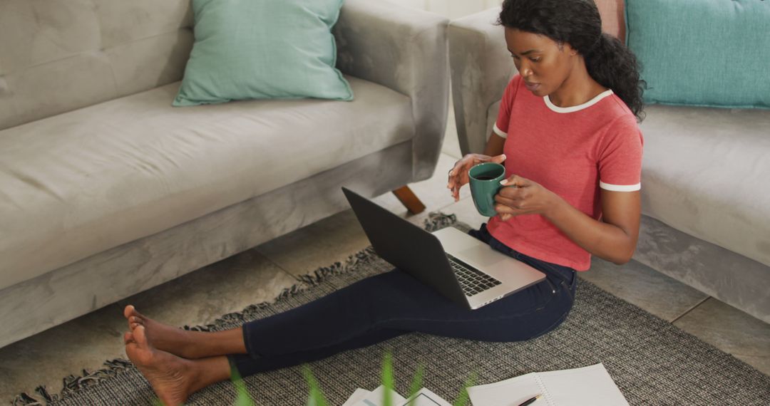 Image of happy african american woman sitting on floor using laptop - Free Images, Stock Photos and Pictures on Pikwizard.com