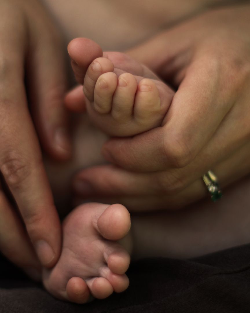 Photograph of parent holding baby's feet