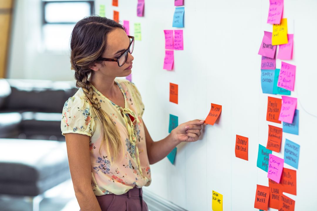 Image of a Woman Putting Sticky Notes on a Whiteboard