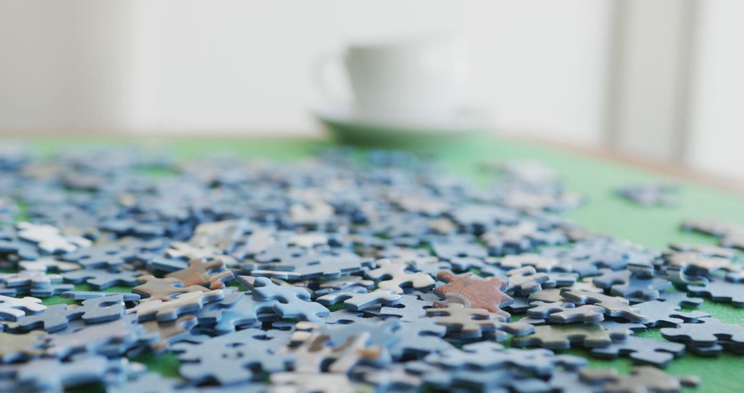 Image of puzzles and cups of coffee on green table - Free Images, Stock Photos and Pictures on Pikwizard.com