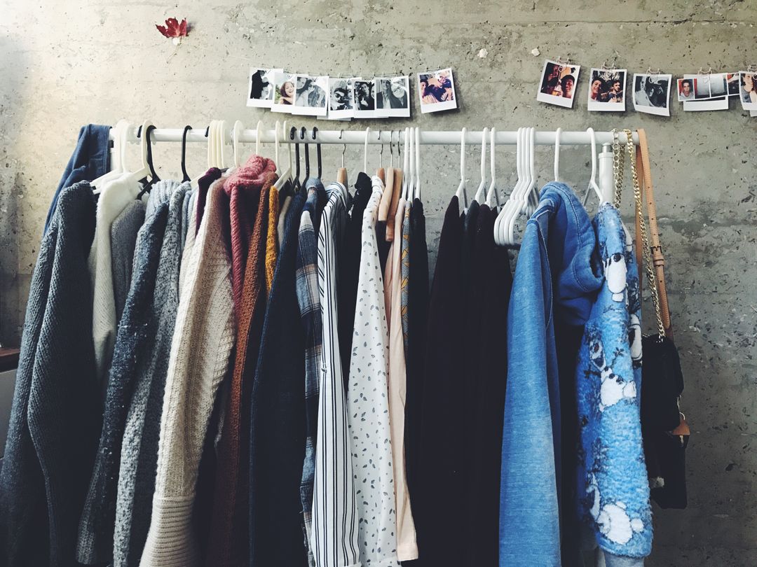 Photograph of clothes on a rack with polaroid images in the background