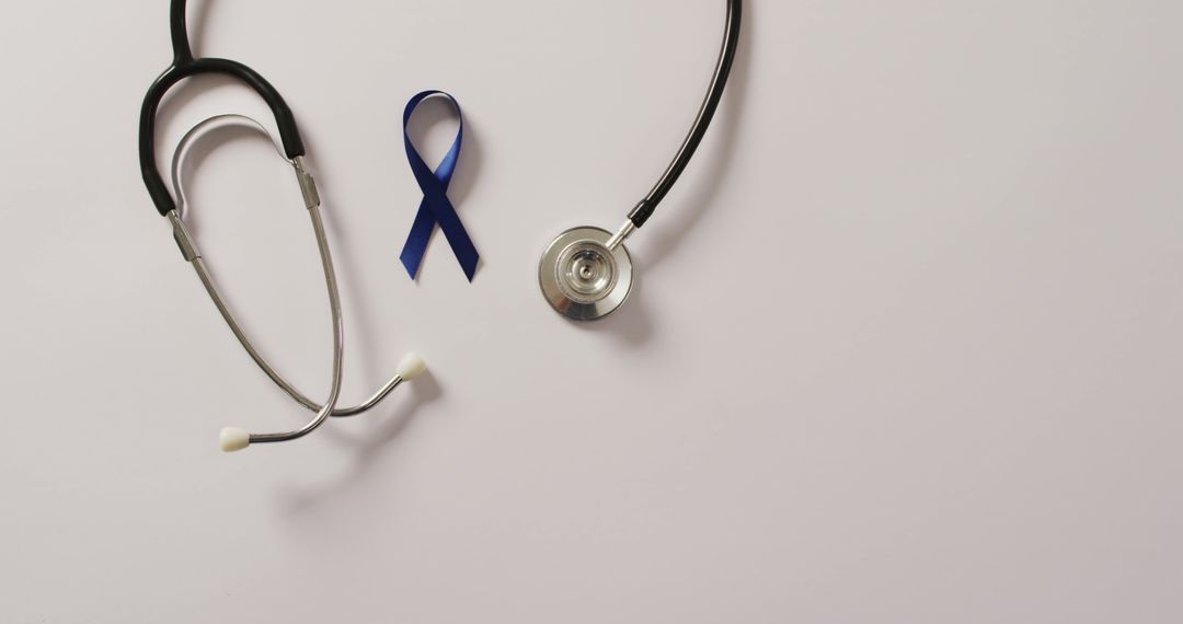 Image of stethoscope and dark blue colon cancer ribbon on white background - Free Images, Stock Photos and Pictures on Pikwizard.com