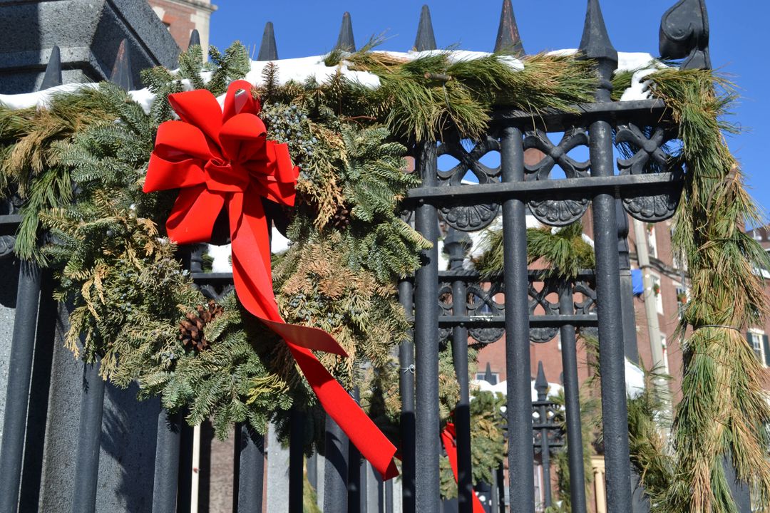a fence with a wreath and a red ribbon - Free Images, Stock Photos and Pictures on Pikwizard.com