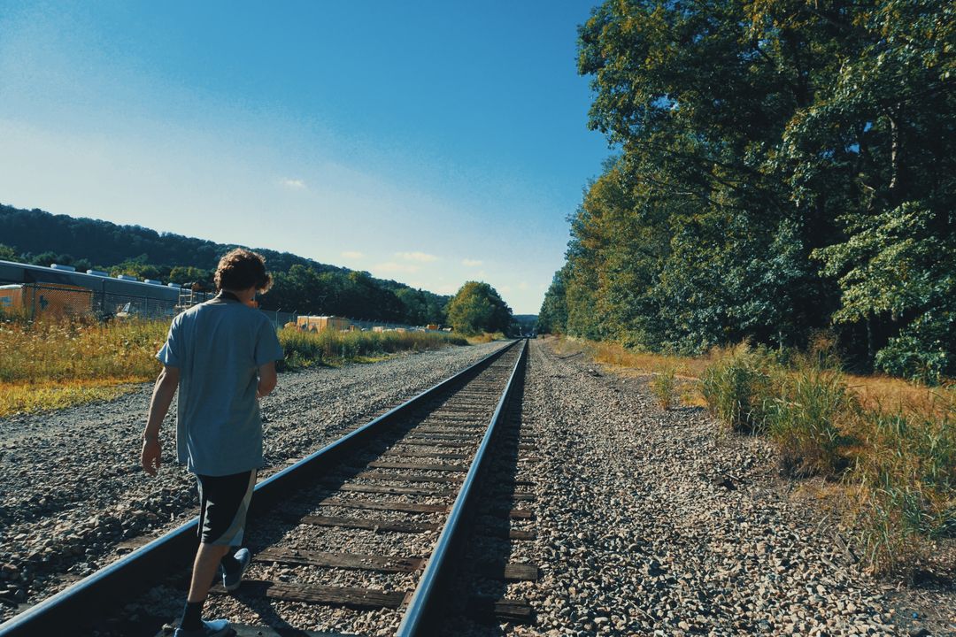 a person walking on a railroad track - Free Images, Stock Photos and Pictures on Pikwizard.com