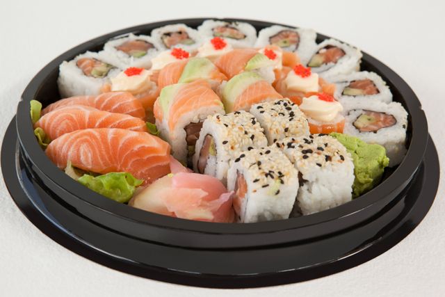 Set of assorted sushi kept in a round black box - Download Free Stock Photos Pikwizard.com