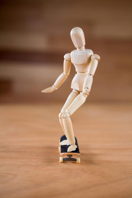 Figurine skateboarding on a wooden floor - Download Free Stock Photos Pikwizard.com