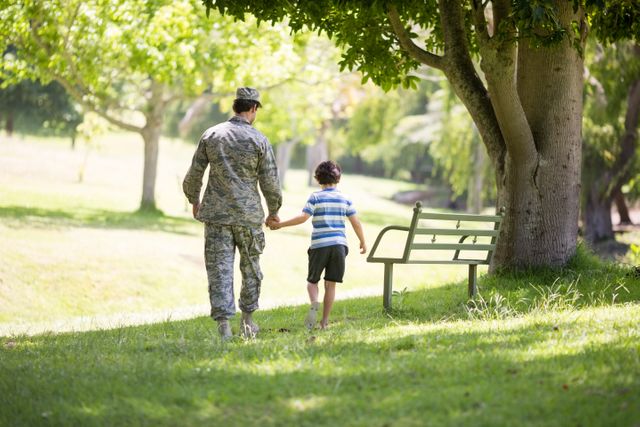 Army soldier walking with boy in park - Download Free Stock Photos Pikwizard.com