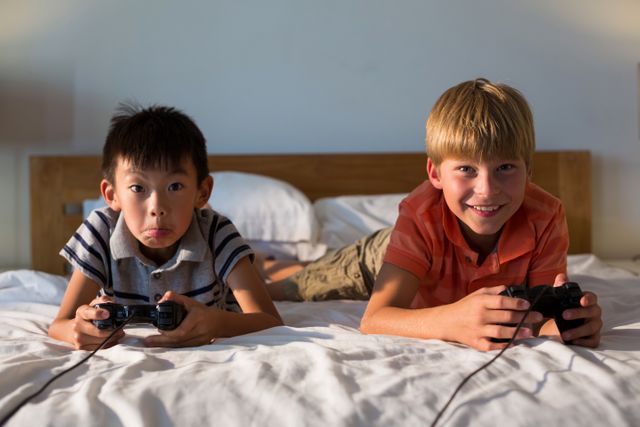 Siblings playing video game on bed - Download Free Stock Photos Pikwizard.com