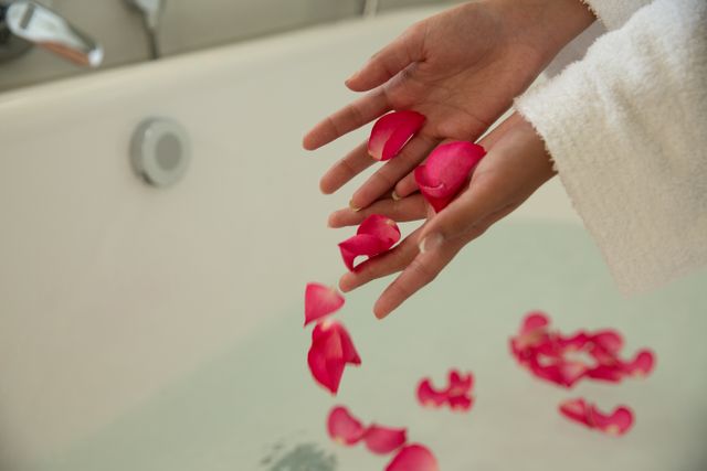 Mid section of woman putting rose petals in bathtub - Download Free Stock Photos Pikwizard.com