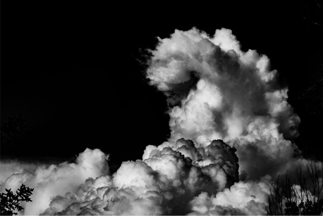 black and white image of Smoke clouds against black background. 