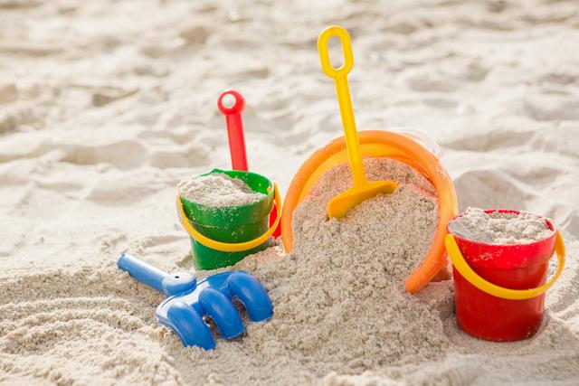 Three buckets with sand and a spade on beach - Download Free Stock Photos Pikwizard.com