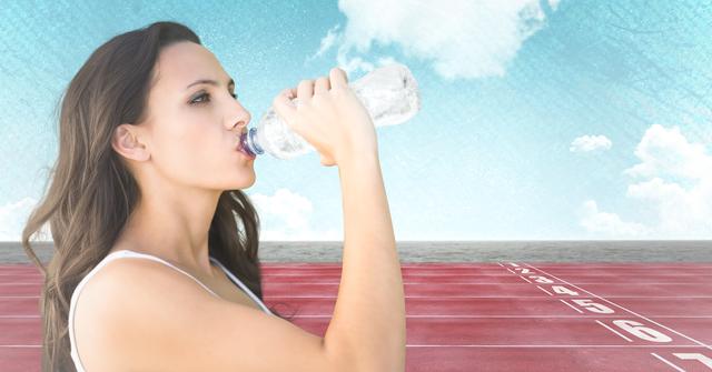 Female runner drinking on track against sky - Download Free Stock Photos Pikwizard.com
