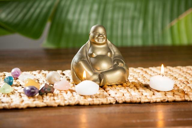 Laughing buddha figurine, pebbles stone and lit candles - Download Free Stock Photos Pikwizard.com