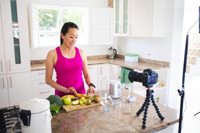 Asian female vlogger slicing fruits to make healthy juice at home - Download Free Stock Photos Pikwizard.com