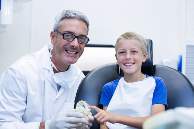 Portrait of smiling dentist and young patient - Download Free Stock Photos Pikwizard.com