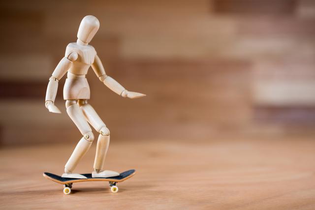 Figurine skateboarding on a wooden floor - Download Free Stock Photos Pikwizard.com