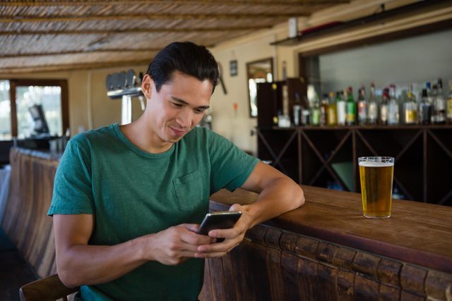 Man using phone while sitting at bar counter - Download Free Stock Photos Pikwizard.com