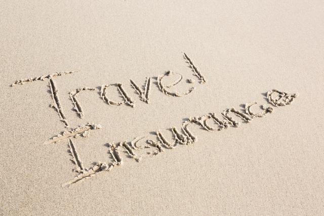 Travel Insurance written on sand at beach