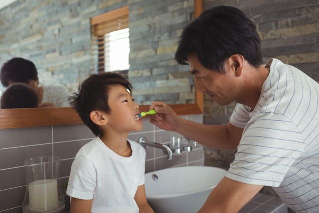 Father brushing his sons teeth in bathroom - Download Free Stock Photos Pikwizard.com