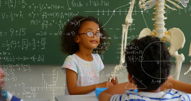 Image of mathematical equations floating over schoolchildren sitting in classroom, looking at human- Download Free Stock Photos Pikwizard.com