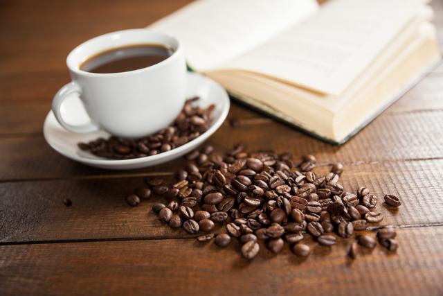 Cup of coffee with coffee beans and book - Download Free Stock Photos Pikwizard.com