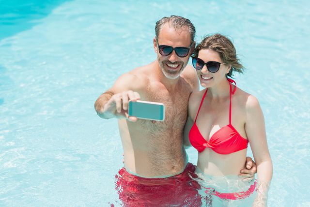 Happy couple taking selfie from mobile phone in pool - Download Free Stock Photos Pikwizard.com