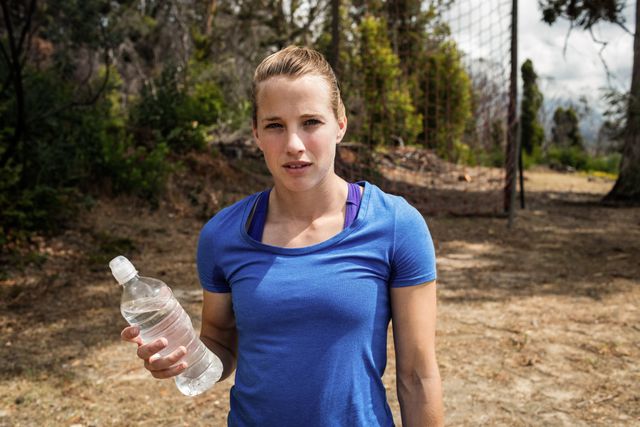 Fit woman holding a water bottle in boot camp - Download Free Stock Photos Pikwizard.com